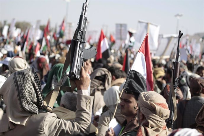 Archivo - 12 January 2024, Yemen, Sanaa: People hold up weapons, wave Palestinian flags and chant slogans during a protest against a multinational operation to protect shipping in the Red Sea following US and UK airstrikes on Huthi military installations.