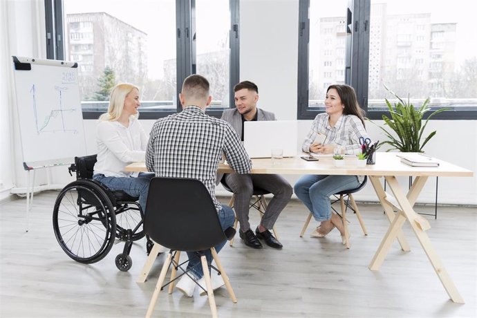 Archivo - Una mujer en silla de ruedas en unas oficinas