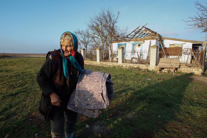 Archivo - 12 November 2022, Ukraine, Kherson Oblast: A Ukrainian elderly woman collects humanitarian aids outside her home in a village that was attacked by the Russian forces, close to the recently liberated Kherson City. Photo: Daniel Ceng Shou-Yi/ZUMA 