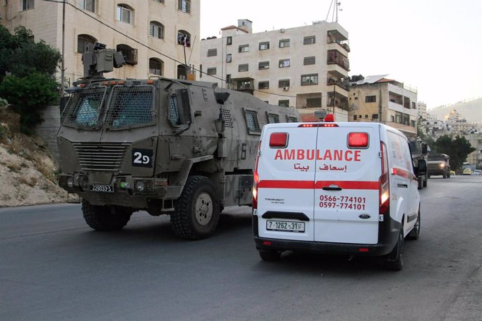 Vehículo militar israelí junto a una ambulancia en Nablús, Cisjordania