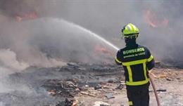 Un bombero sofocando el fuego producido en el polígono El Portal de Jerez de la Frontera (Cádiz).