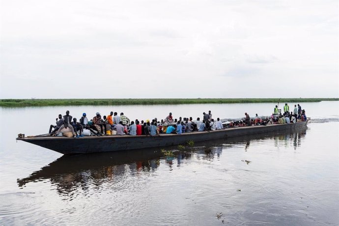 Archivo - Refugiados sudaneses y retornados de Sudán del Sur toman una barcaza en el puerto de Renk, Sudán del Sur.