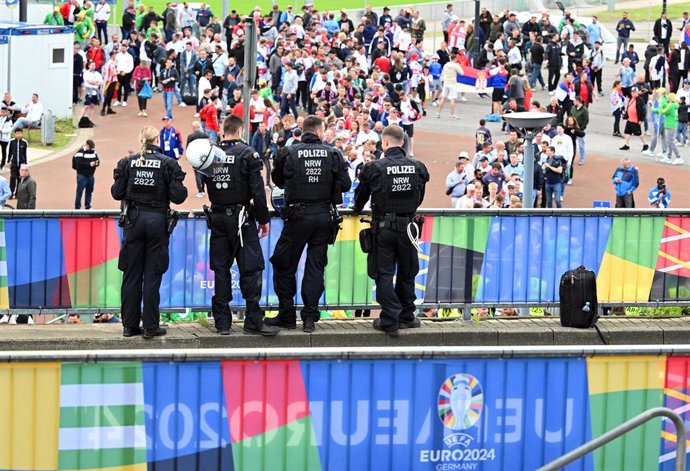 16 June 2024, North Rhine-Westphalia, Gelsenkirchen: Police officers stand in front of the stadium while the fans arrive for the UEFA EURO 2024 Group C soccer match between Serbia and England at Arena AufSchalke. Photo: Bernd Thissen/dpa