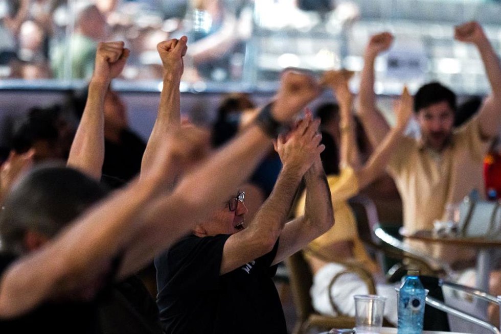 Varias personas celebran un gol viendo en una pantalla grande el partido de la Eurocopa entre España y Croacia.