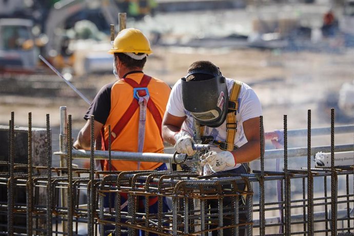 Archivo - Un soldador y un operario trabajando en unas obras