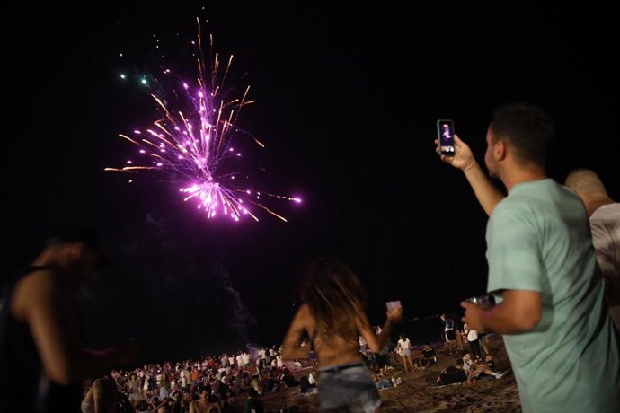 Archivo - Un hombre graba los fuegos artificiales durante la tradicional verbena de Sant Joan