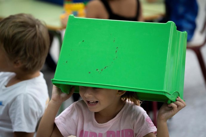 Archivo - Arxiu - Una xiqueta sosté una caixa de plàstic al CEIP El Grau amb motiu de l'inici del curs escolar