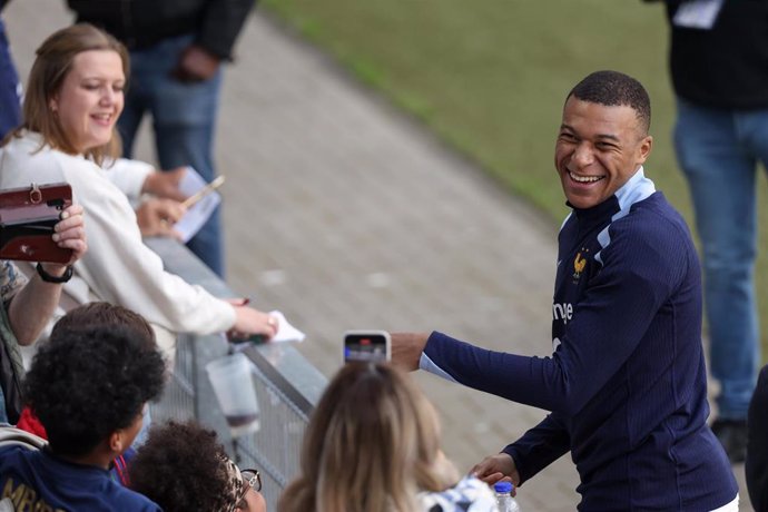 13 June 2024, North Rhine-Westphalia, Paderborn: France's Kylian Mbappe signs autographs during a training session for the team, as part of their preparations for the UEFA EURO 2024. Photo: Friso Gentsch/dpa