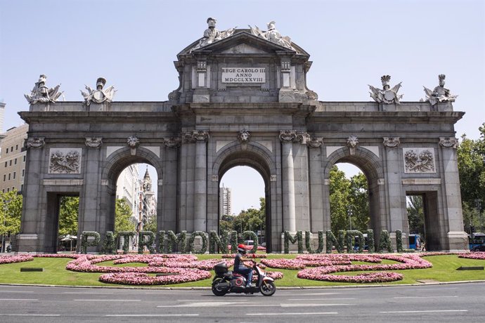 Archivo - Una moto pasa por las letras gigantes que forman la palabra ‘Patrimonio Mundial’ en la Puerta de Alcalá, a 10 de agosto de 2021, en Madrid (España). El Ayuntamiento de Madrid ha instalado estas letras de 35 metros de longitud, recubiertas de hoj