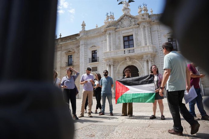 Profesores de la Universidad de Sevilla tras la verja cerrada de la entrada principal de la US, se manifiestan en apoyo de los estudiantes desalojados por la policía. 