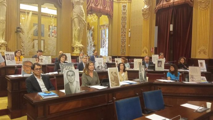Diputados socialistas sostienen varias pancartas con fotografías durante el debate de toma en consideración la derogación de la ley de memoria democrática.