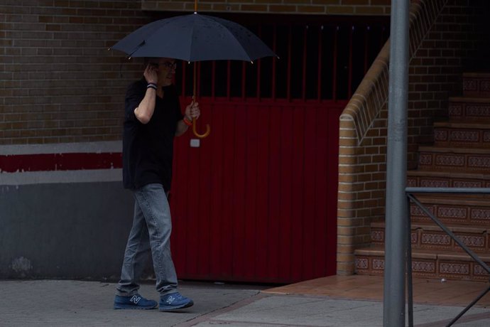 Un hombre se protege de la lluvia con un paraguas, a 8 de junio de 2024, en Madrid (España). 