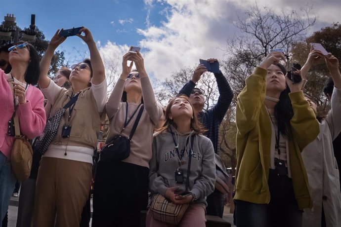 Archivo - Varios turistas se hacen fotos junto a la Sagrada Familia.