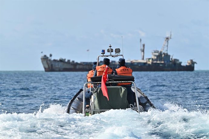 Agentes de la Guardia Costera de China inspeccionan un buque de transporte de la Marina filipina encallado deliberadamente en el mar de China Meridional