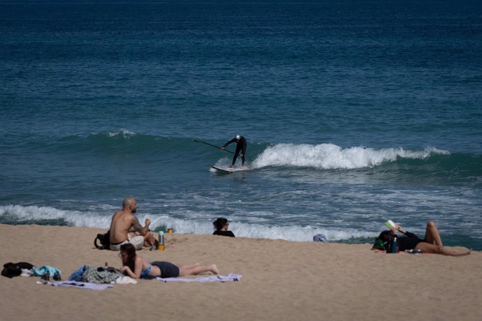 Archivo - Varias personas toman el sol en la playa 