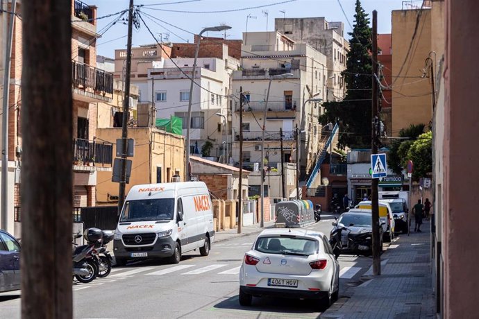 Una calle de Barcelona con palos de apoyo de cableado eléctrico y de telecomunicaciones.