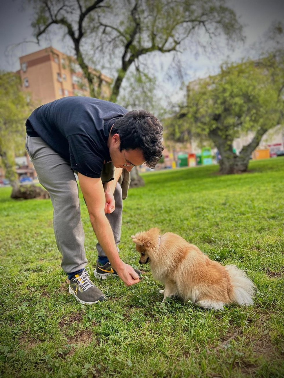 Un joven con su perro en un parque