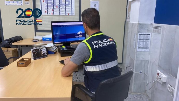 Agente de la Policía Nacional frente a un ordenador.