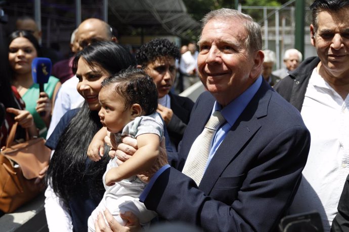 Archivo - 16 May 2024, Venezuela, Caracas: Edmundo Gonzalez Urrutia (C), opposition candidate in the upcoming presidential election, smiles with a child in his arms after an event organized by the Encuentro Ciudadano party. The presidential election will 