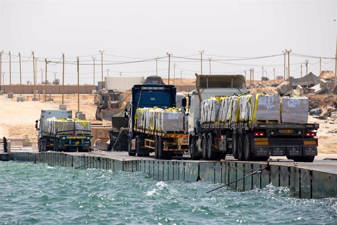 Archivo - Camiones con ayuda humanitaria en el muelle temporal en la costa de la Franja de Gaza
