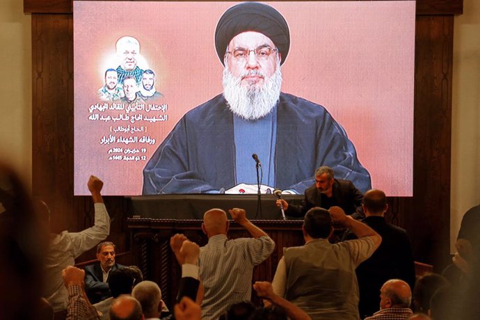 June 19, 2024, Beirut, Beirut, Lebanon: Supporters of pro-Iranian Hezbollah raise their fists as the party Secretary General Hassan Nasrallah appears to give a televised speech during a mass rally to mark one week of the assassination of top party command