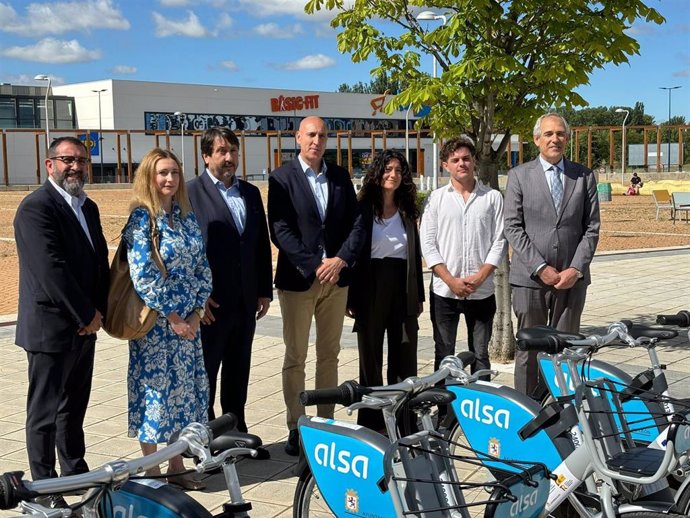 El alcalde posa junto a los miembros de las empresas adjudicatarias del servicio municipal de bicis frente a una de las nuevas estaciones, inaugurada en La Lastra