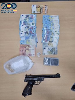 El dinero en efectivo, la cocaína y el arma intervenidos en el local.