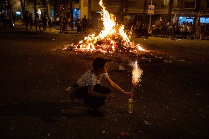 Archivo - Una persona davant d'una foguera durant la tradicional revetlla de Sant Joan