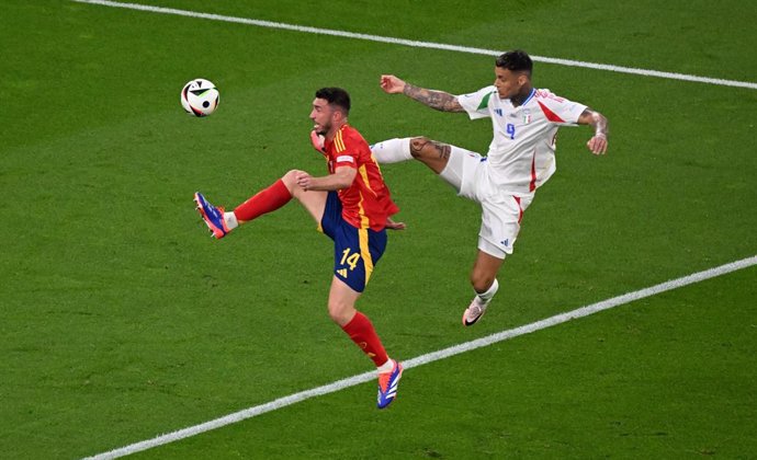 20 June 2024, North Rhine-Westphalia, Gelsenkirchen: Spain's Aymeric Laporte (l) and Italy's Gianluca Scamacca fight for the ball during the UEFA Euro 2024 Group B soccer match between Spain and Italy at Arena auf Schalke. Photo: Julian Stratenschulte/dpa