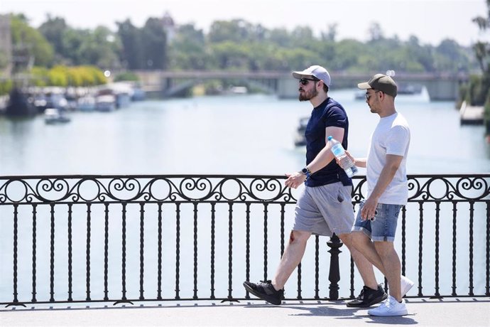 Un joven porta una botella de agua para sofocar el calor en Sevilla en una imagen de archivo