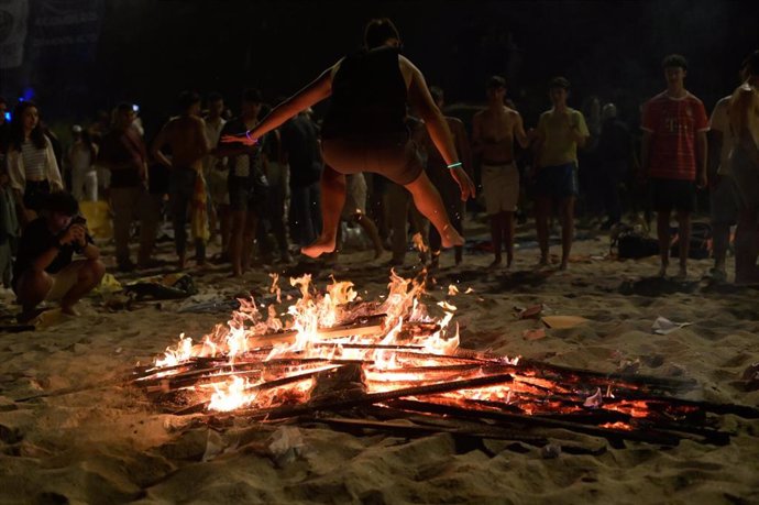 Archivo - Una persona salta una hoguera durante la Noche de San Juan, en la playa de Riazor, a 23 de junio de 2023, en A Coruña, Galicia (España). La Noche de San Juan se celebra en la madrugada del 23 al 24 de junio. Uno de los emblemas de esta festivida