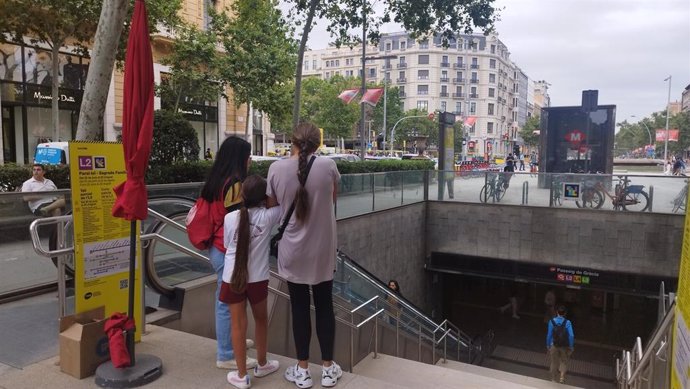 Una informadora explica a dos personas el corte en la L2 del Metro de Barcelona.