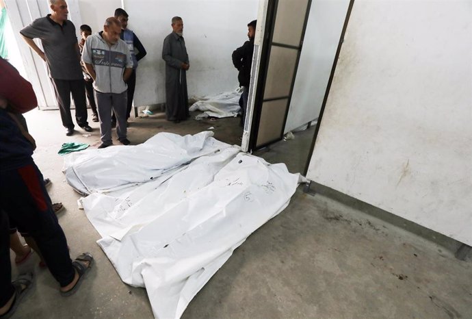 Un grupo de palestinos en la morgue de una clínica frente a los cuerpos de varios muertos en un bombardeo del Ejército de Israel contra un campamento de desplazados en Rafá, en el sur de la Franja de Gaza (archivo)