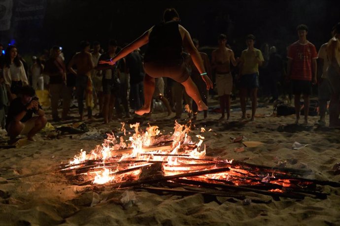 Archivo - Arquivo - Unha persona salta unha fogueira durante a Noite de San Juan, na praia de Riazor, a 23 de xuño de 2023, na Coruña, Galicia (España). A Noite de San Juan celébrase na madrugada do 23 ao 24 de xuño. Un dos emblemas desta festivida