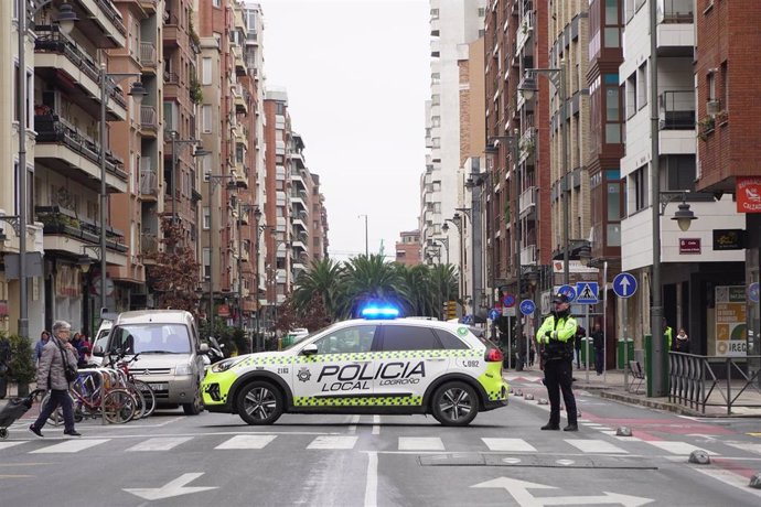 Archivo - Un vehículo y un agente de Policía Local en una calle de Logroño