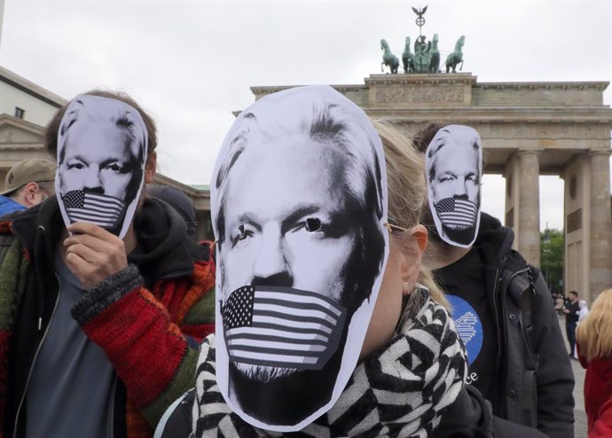 Archivo - FILED - 02 May 2019, Berlin: Supporters of WikiLeaks founder Julian Assange wear masks during a protest against his arrest and extradition to USA in front of the Brandenburg Gate. Photo: Wolfgang Kumm/dpa