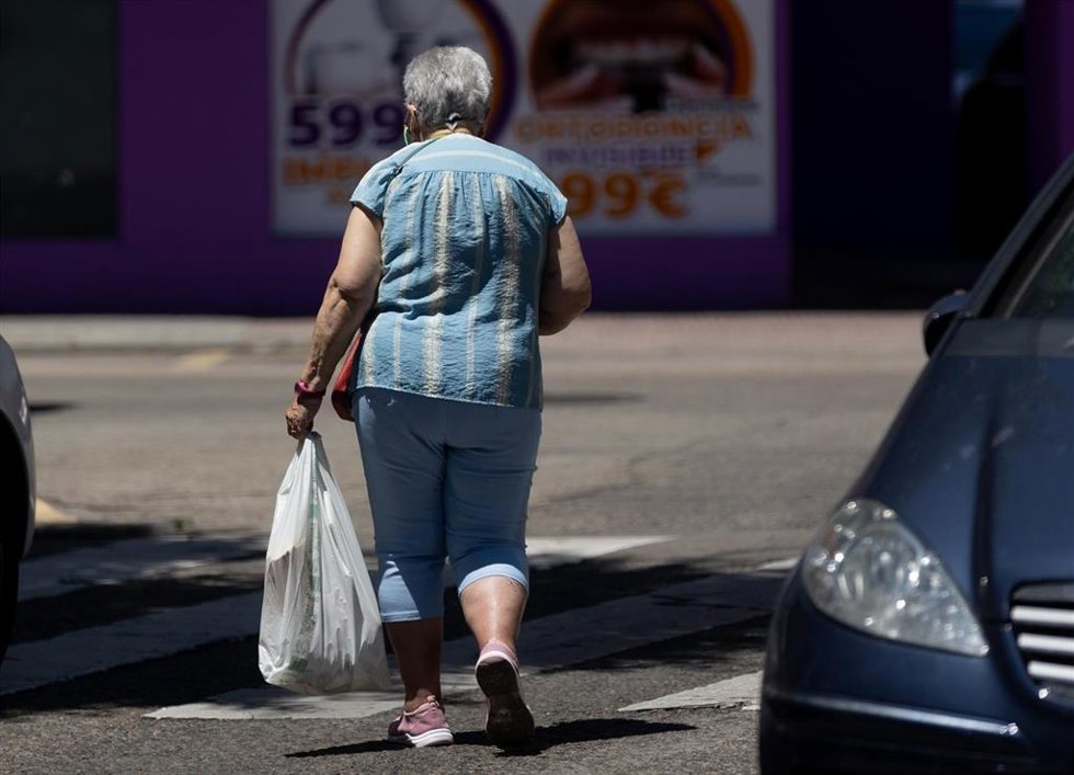 Una señora mayor sujeta una bolsa mientras camina, a 24 de junio de 2024
