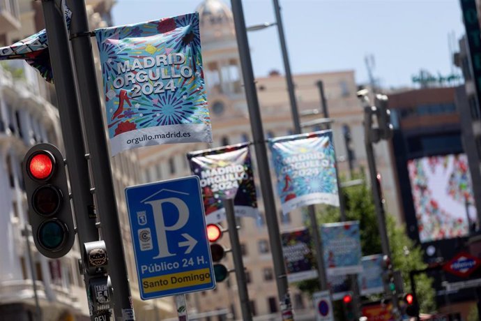 Varios carteles del Orgullo 2024 colgados de farolas, en Gran Vía.