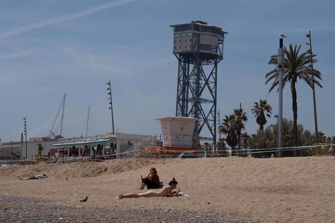 Archivo - Varias personas toman el sol en la playa de la Barceloneta, a 25 de abril de 2023, en Barcelona, Catalunya (España)
