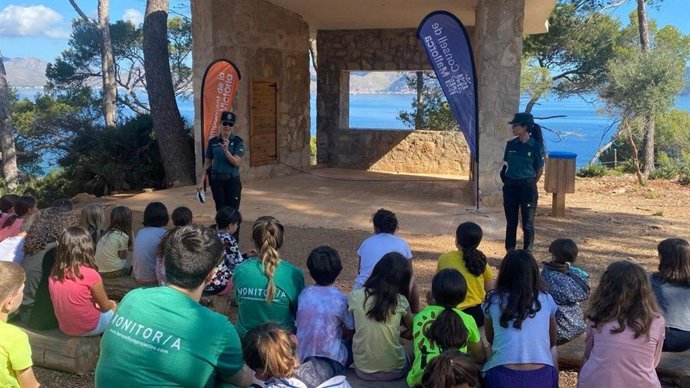 Agentes de la Guardia Civil ofrecen una charla en un campamento.