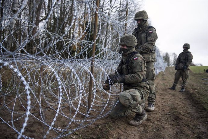 Archivo - Soldados polacos contruyen una valla en la frontera. 