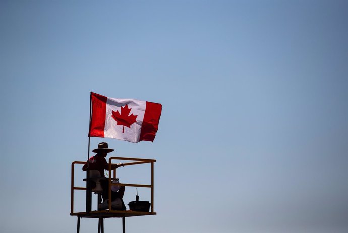 Archivo - 06 July 2021, Canada, Surrey: A lifeguard is silhouetted while sitting on a watchtower as a Canadian flag flies in the wind at Crescent Beach, in Surrey. Photo: Darryl Dyck/The Canadian Press via ZUMA/dpa