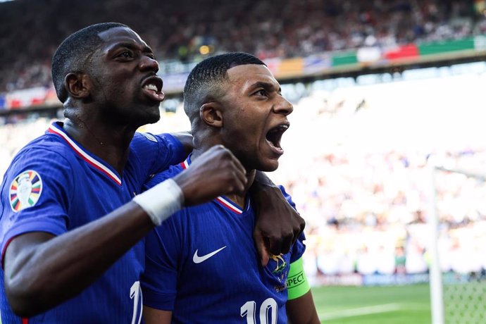 Kylian Mbappé se quita la máscara para celebrar con Ousmane Dembélé su gol en el Francia-Polonia