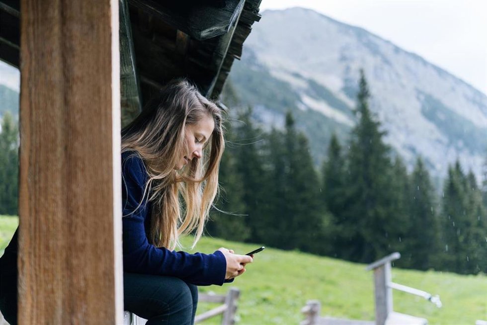 Una mujer utiliza su móvil en un entorno rural