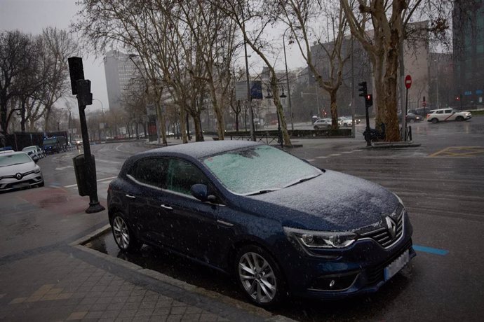 Archivo - Un coche aparcado durante la tormenta, en el centro de Madrid.