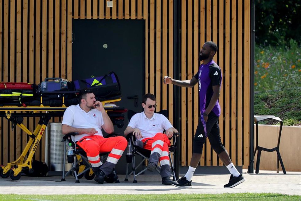 26 de junio de 2024, Baviera, Herzogenaurach: el alemán Antonio Rüdiger camina junto a los paramédicos hacia la sesión de entrenamiento previa al partido de fútbol de octavos de final de la Eurocopa del sábado. Foto: Christian Charisius/dpa