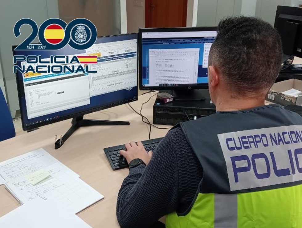 Archivo - Un agente de la Policía ante un ordenador.