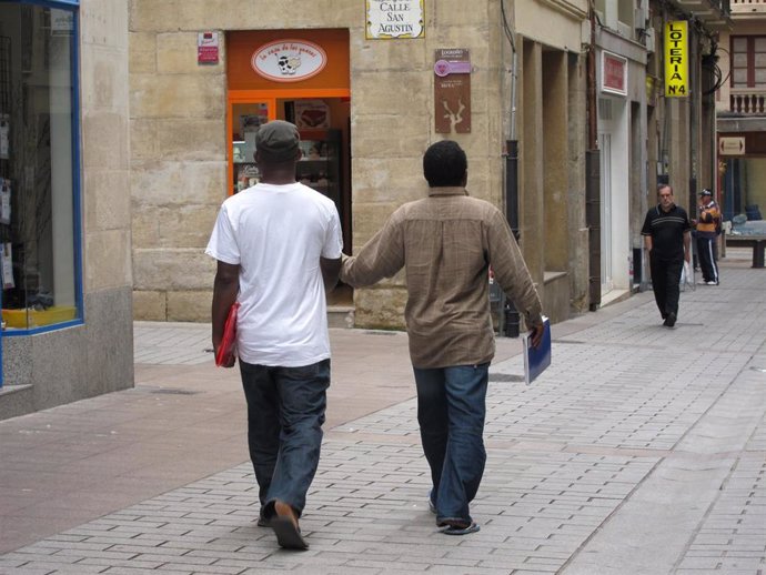 Archivo - Inmigrantes paseando por una ciudad. 