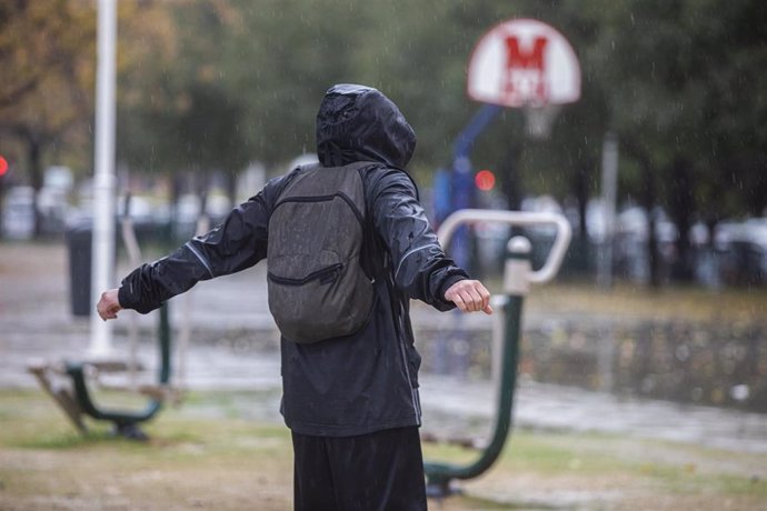 Archivo - Una persona con un chubasquero bajo la lluvia en imagen de archivo. 