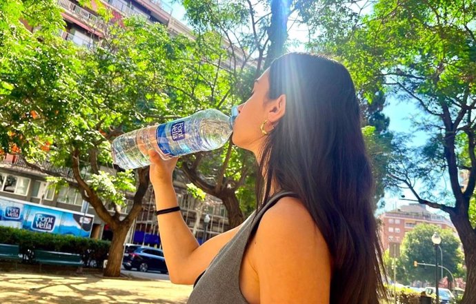 Mujer bebiendo de una botella de agua de Font Vella